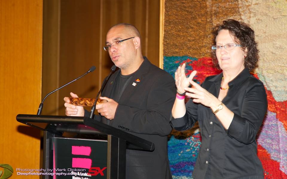 Julie Tait interpreting beside a speaker at a professional event