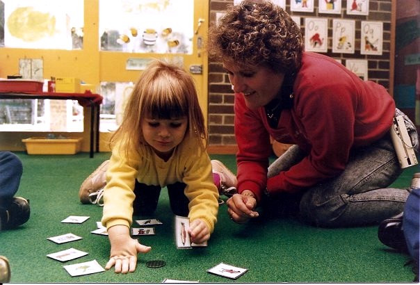 Julie supporting a young Deaf child using picture cards