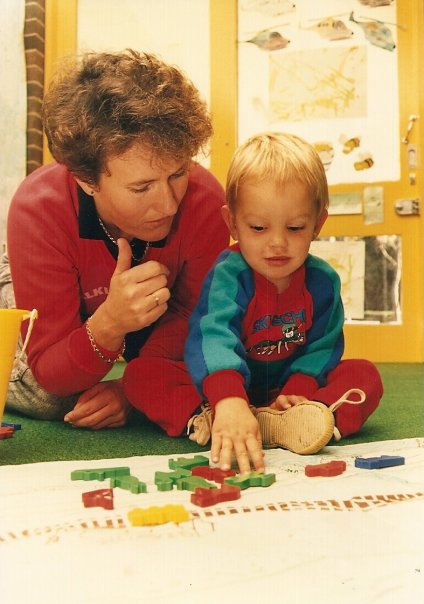 Julie working beside a young Deaf child during a classroom activity