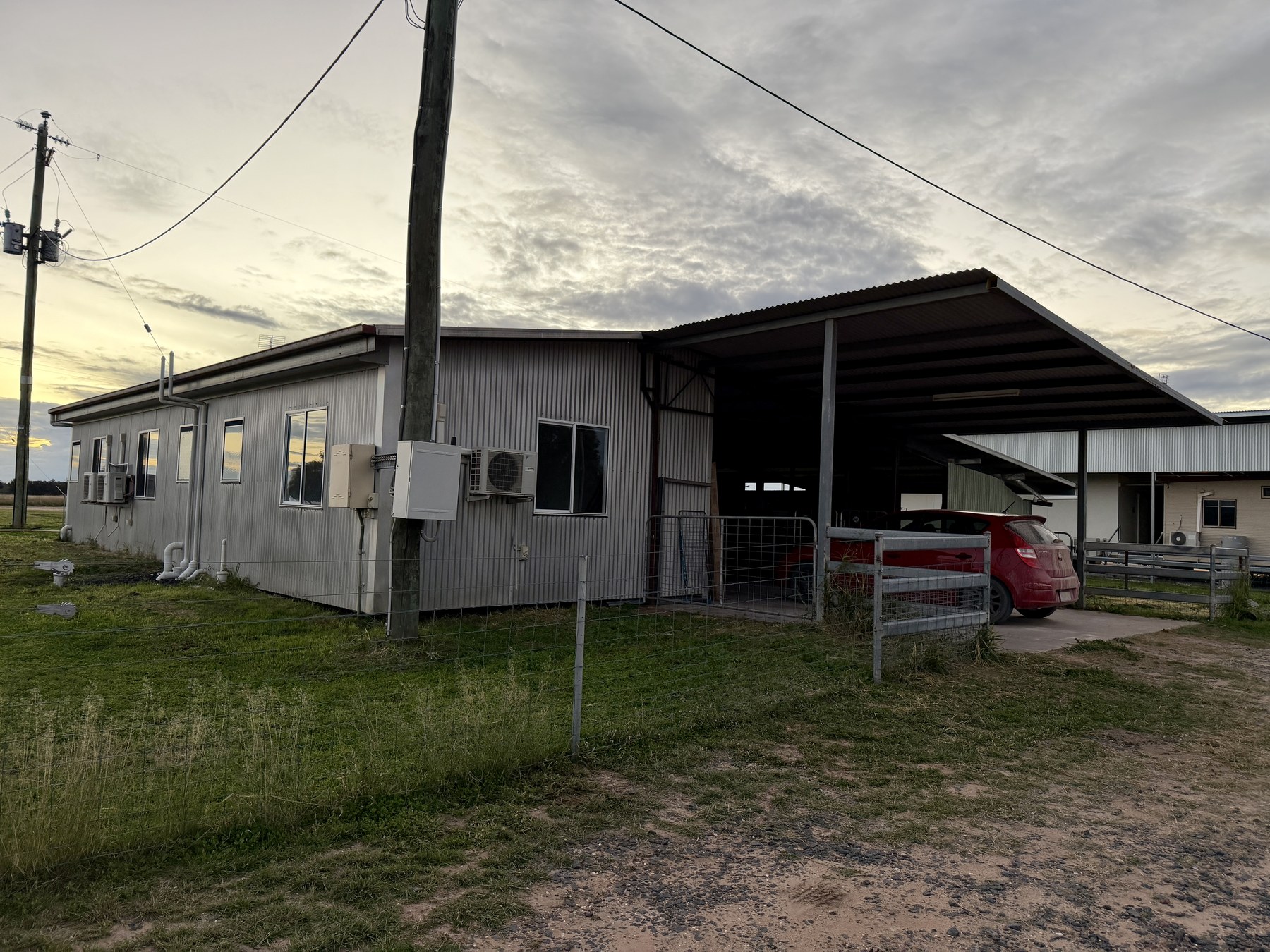Rural workplace buildings at Wallumba Feedlot under an evening sky