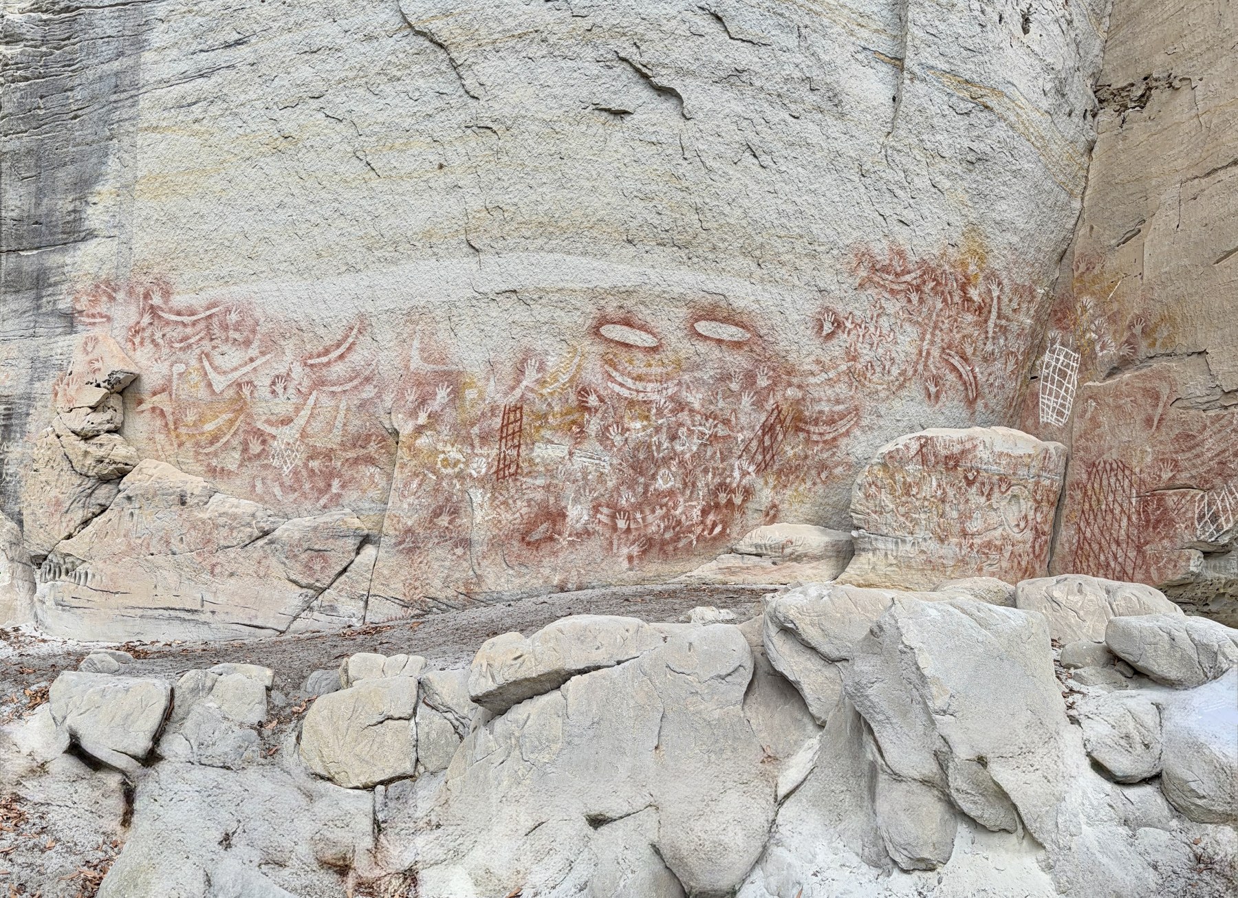 Wide sandstone wall with Aboriginal rock art and hand stencils at Carnarvon Gorge Art Gallery