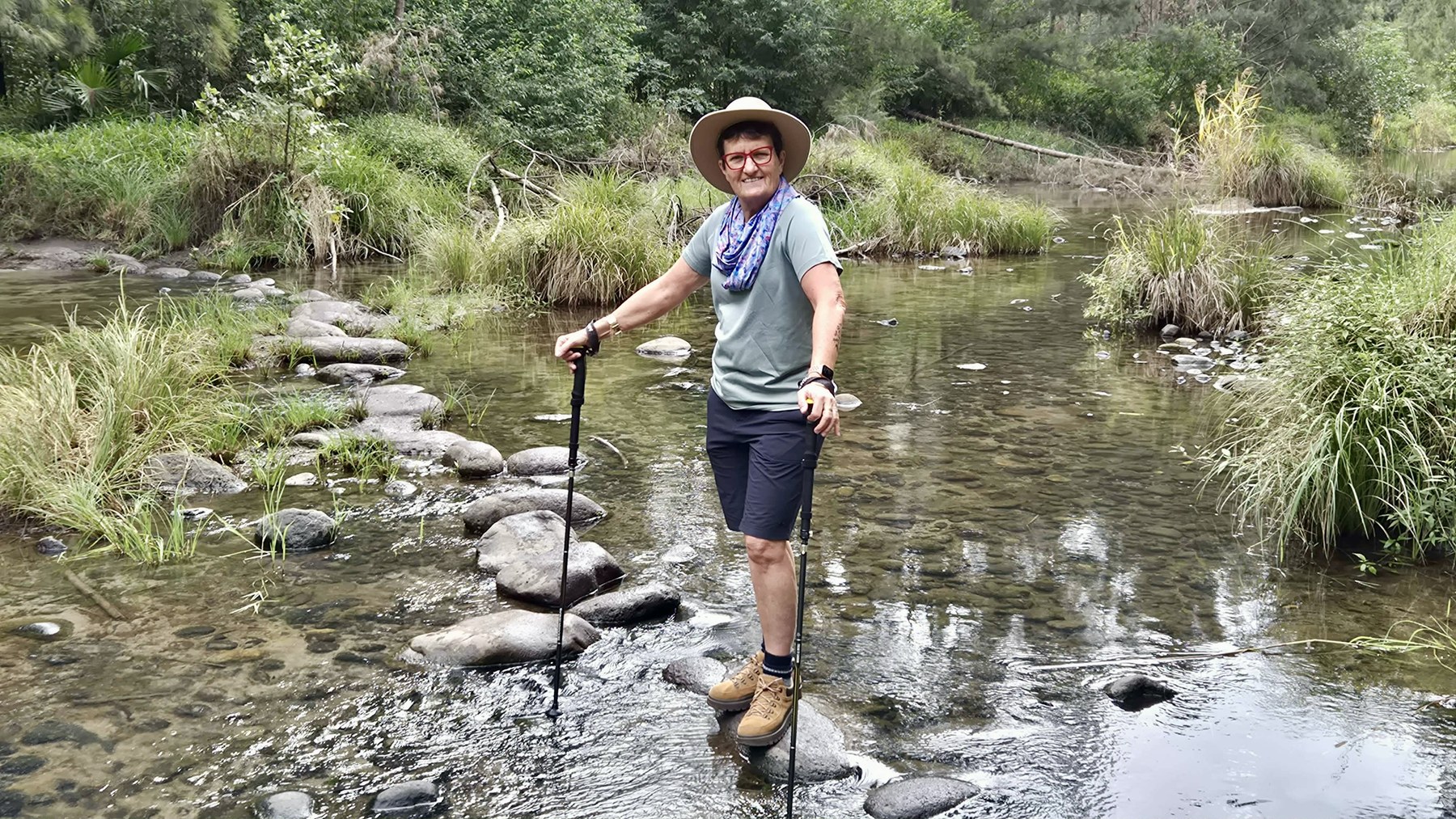 Julie crossing a shallow creek on stepping stones during the Carnarvon Gorge walk