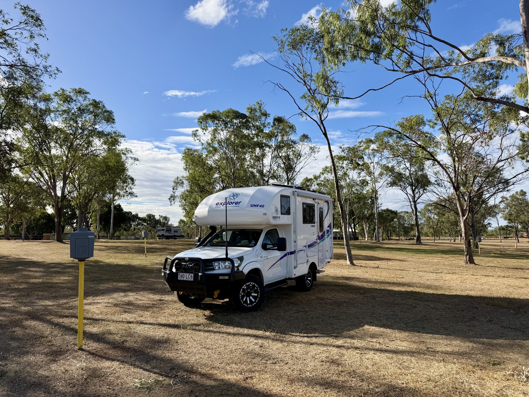 Elcee parked at Clermont Showgrounds among open trees and dry grass