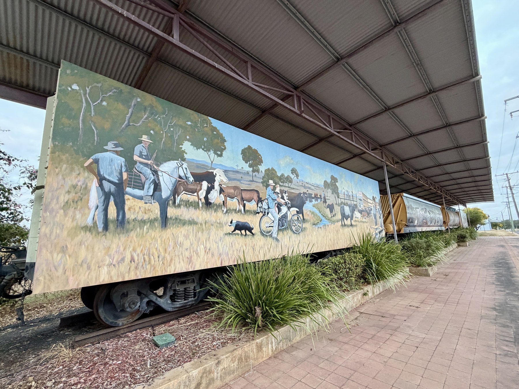 Painted railway mural in Charters Towers showing cattle and local history