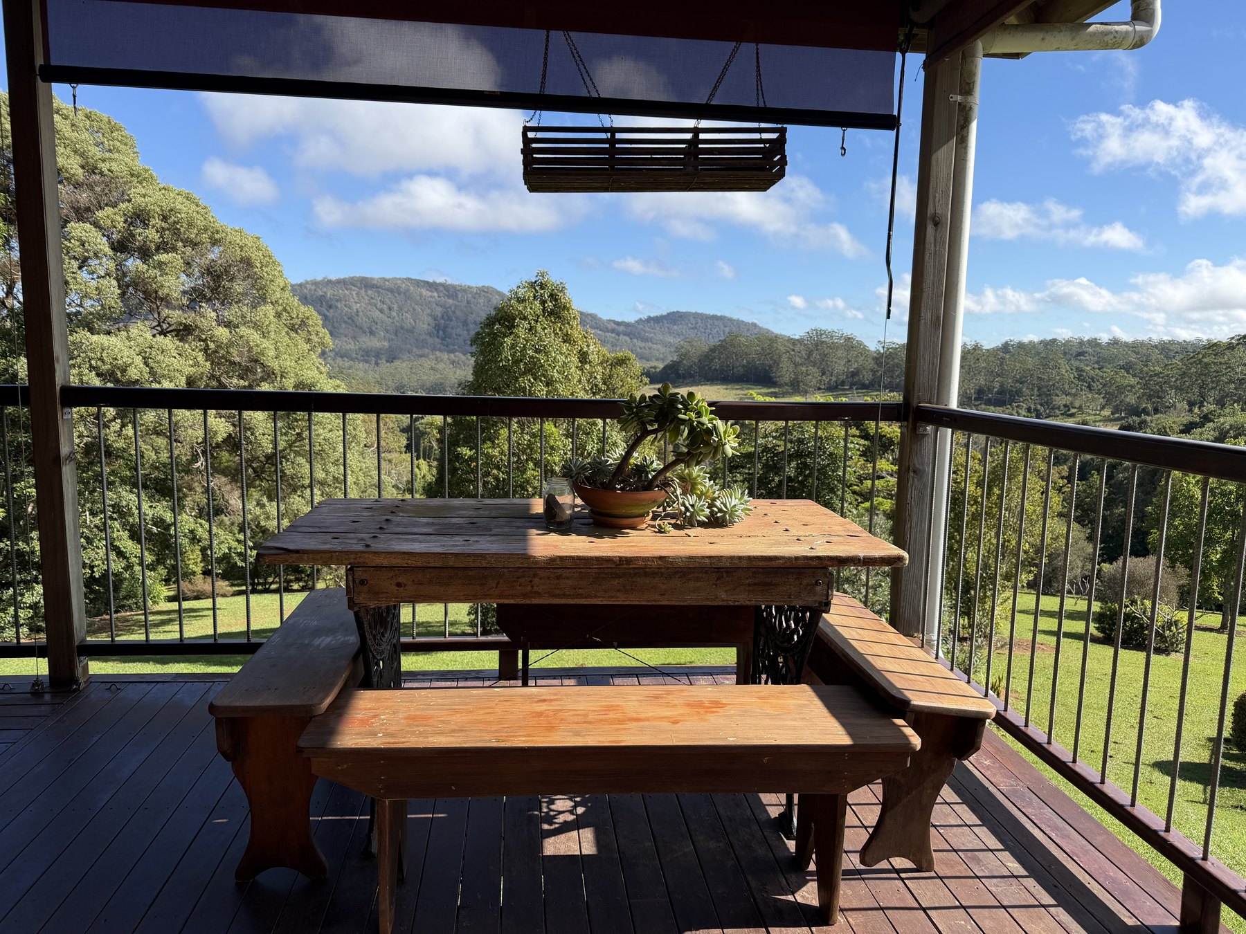 Wooden table on a deck overlooking green hills and valley country near Ravenshoe
