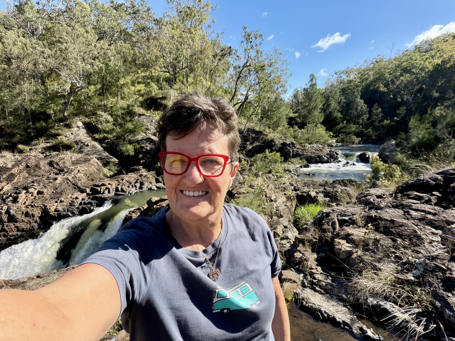 Julie smiling near rocky cascades and bushland