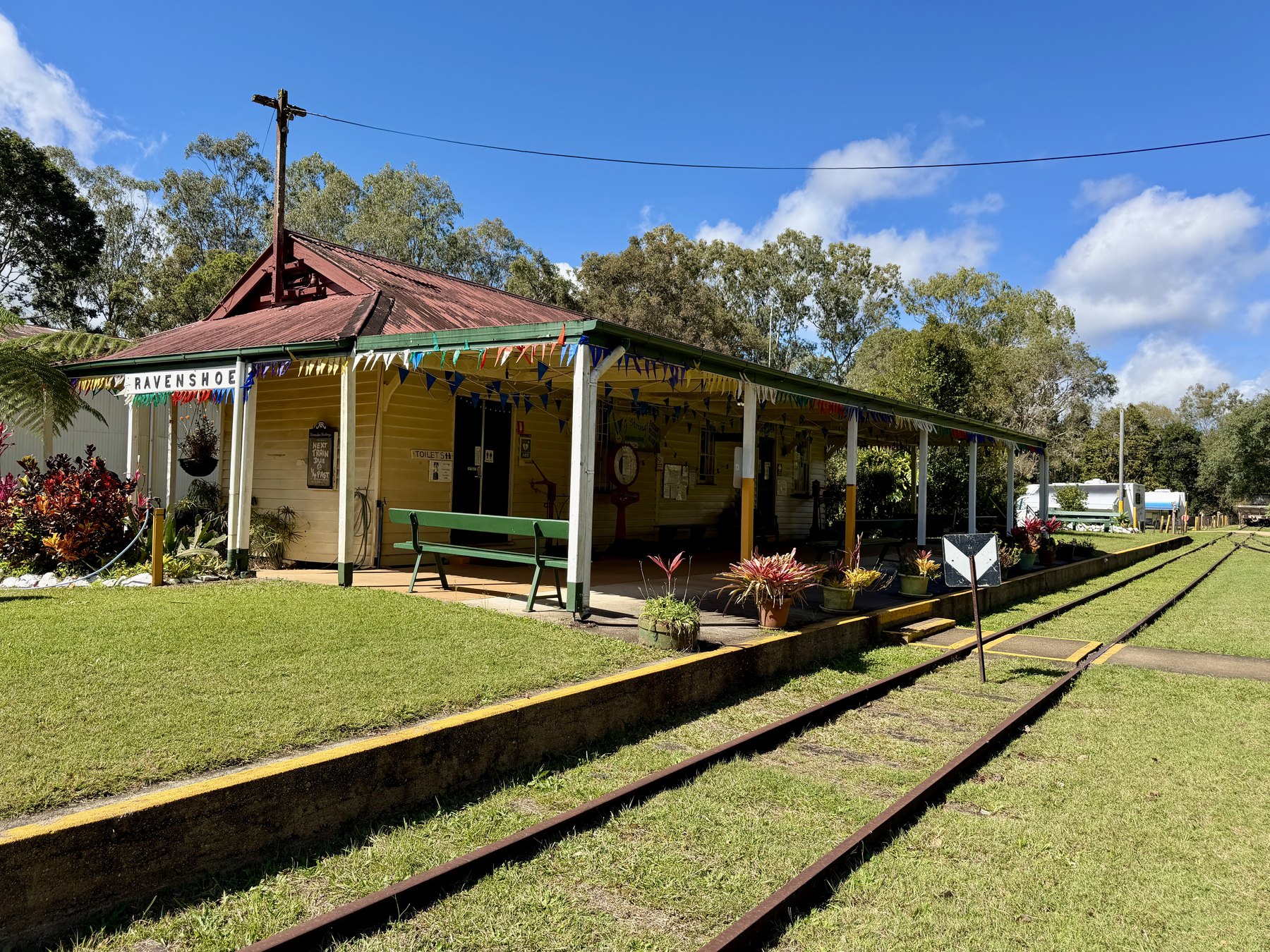 Ravenshoe railway station with tracks, bunting and bright garden beds