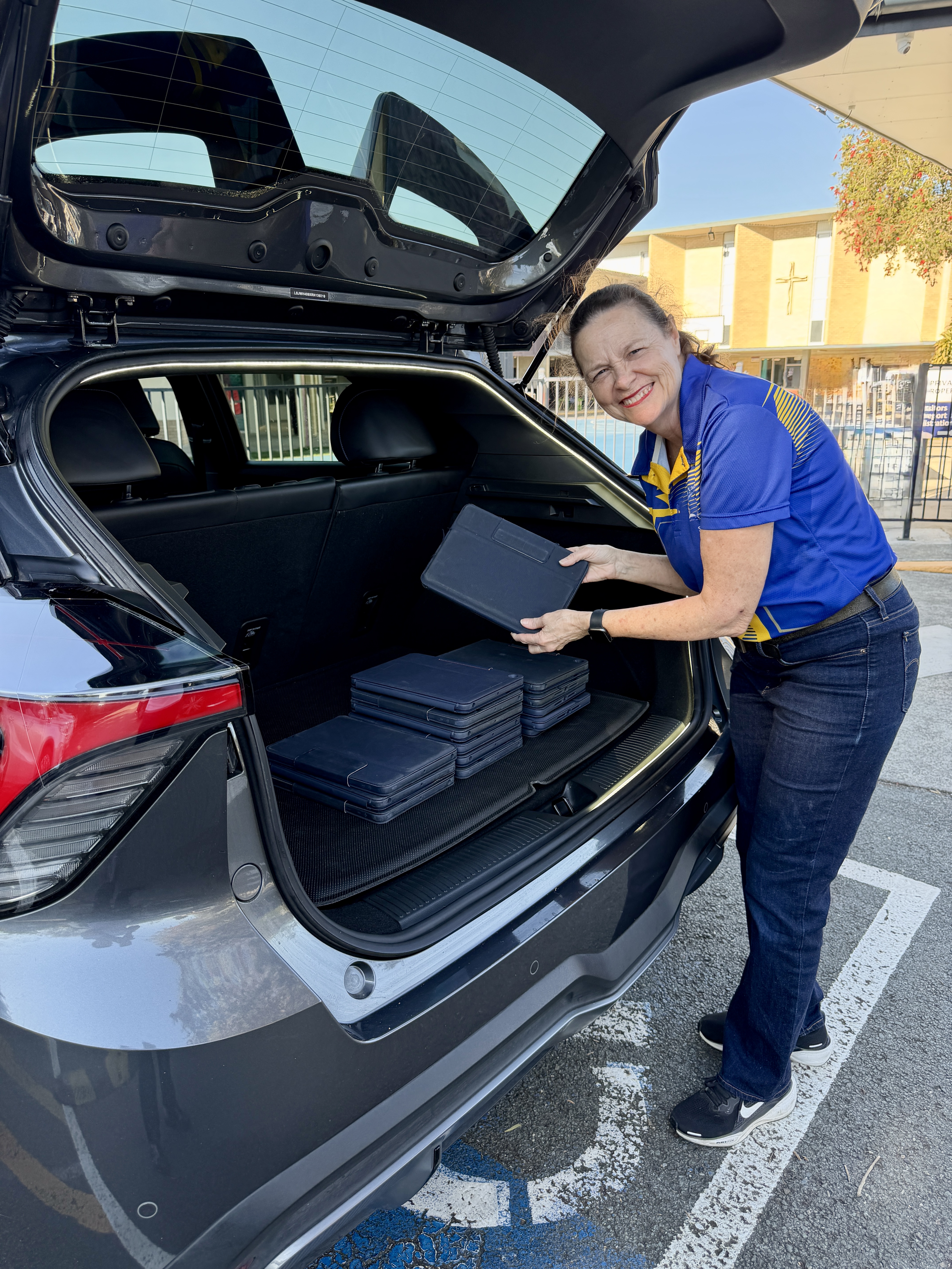 Julie placing collected iPads into a car