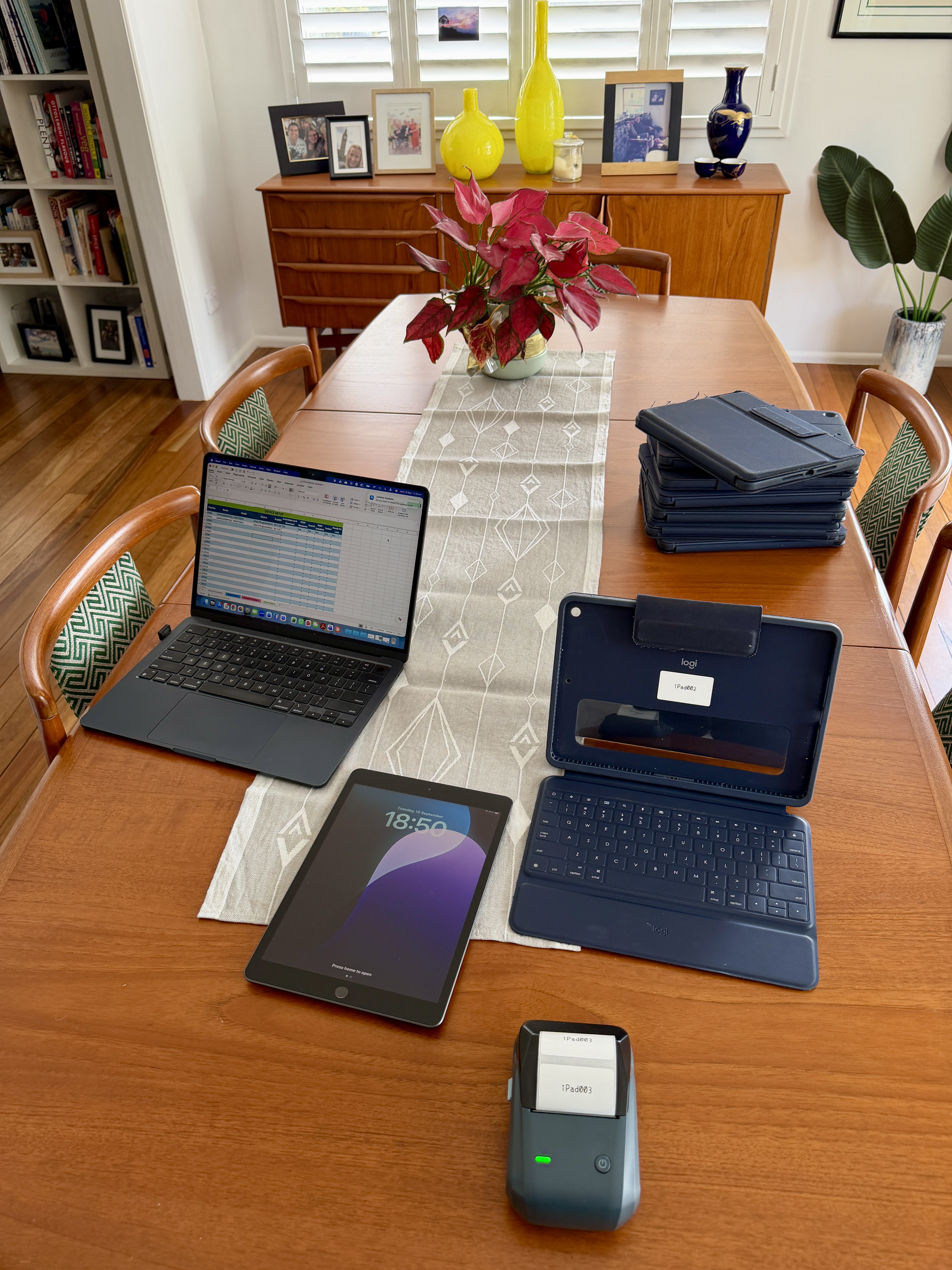 iPads, a laptop and a label printer arranged for travel preparation
